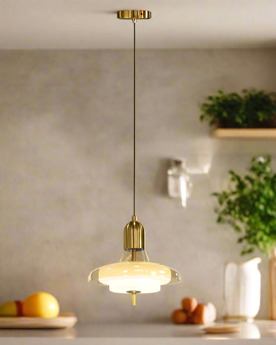 Pendant light with gold fixture and glass shade on a background