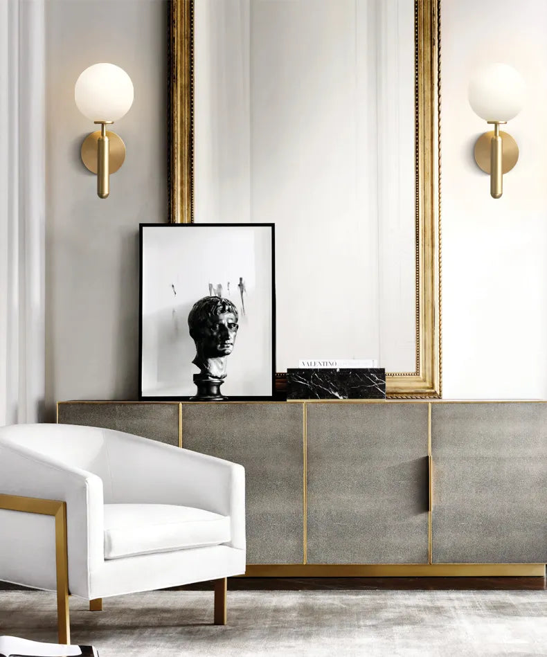 Modern interior design with a white armchair, framed artwork, and GLOW CRYSTAL BALL LED WALL SCONCE LIGHT