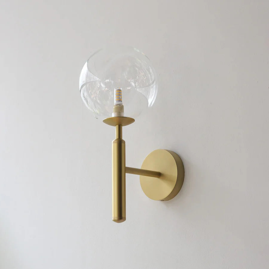 Gold GLOW CRYSTAL BALL LED WALL SCONCE LIGHT with a clear glass globe on a white wall