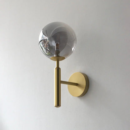 Wall-mounted GLOW CRYSTAL BALL LED WALL SCONCE LIGHT with gold fixture and clear glass shade on a white wall